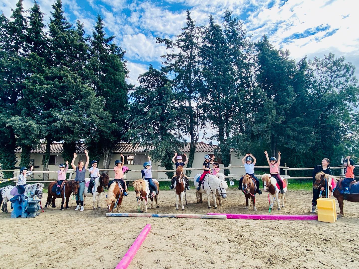 Children on ponies in the arena during a holiday course