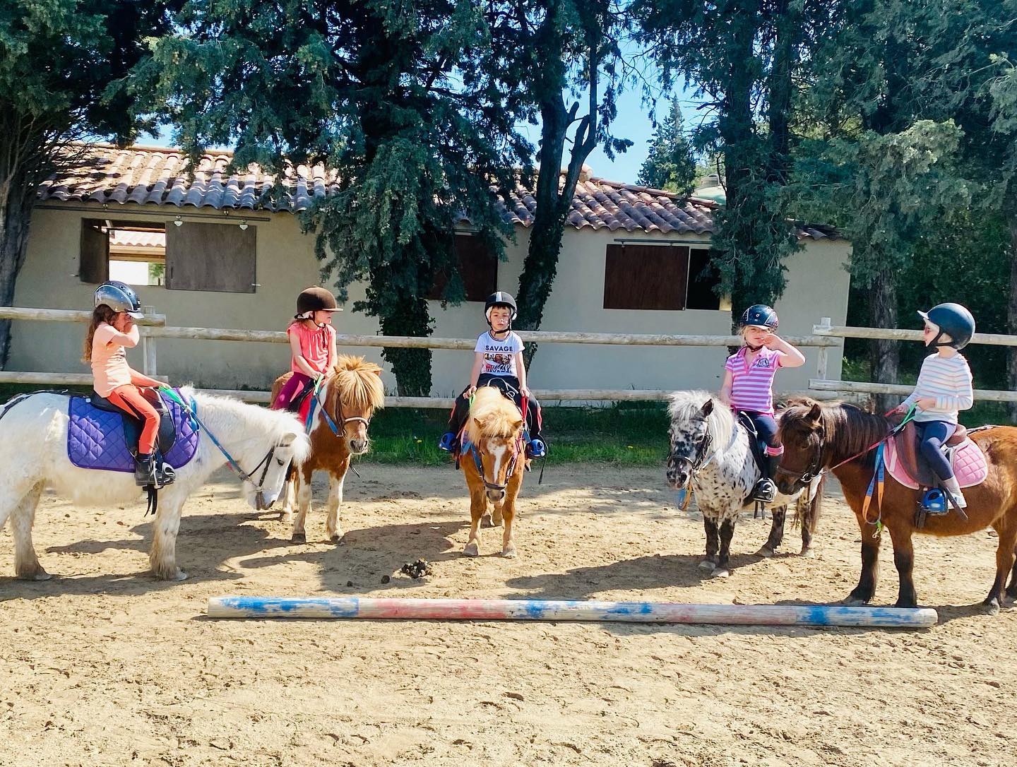 Young riders on ponies in the arena